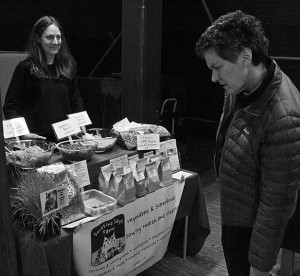 Barbara Spiegel, right, considers buying edible grass from the Serafina Says Farm. Photos by Bruce Frisch.