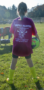 A young member of the soccer team shows off her new t-shirt.