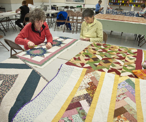 Quilters Lisa Mitchel and Susan Diggle cutting patterns. Photos by Bruce Frisch.