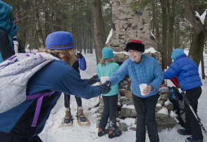 A trekker receives a cup of cocoa from the NLT's Susannah Wood.