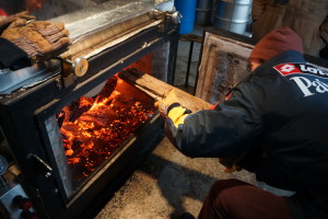 Mead feeds the firebox of his evaporator.