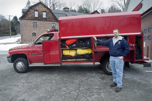 Fire Chief Matthew Ludwig showing the utility truck's exterior cabinets.